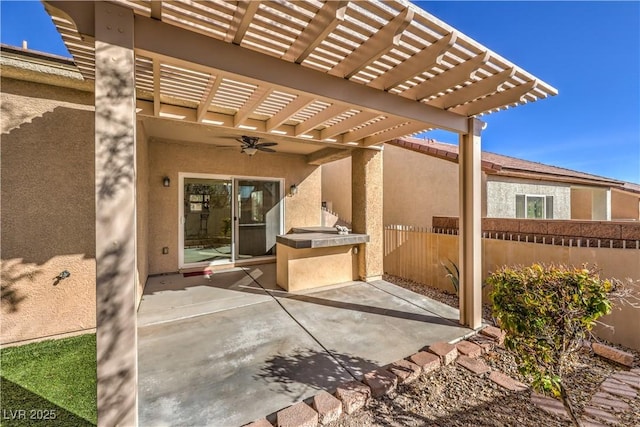 view of patio / terrace with ceiling fan, an outdoor kitchen, and a pergola