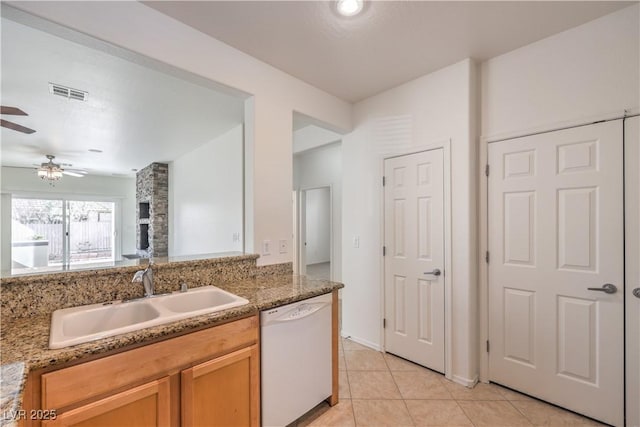 kitchen featuring stone countertops, sink, light tile patterned floors, ceiling fan, and white dishwasher