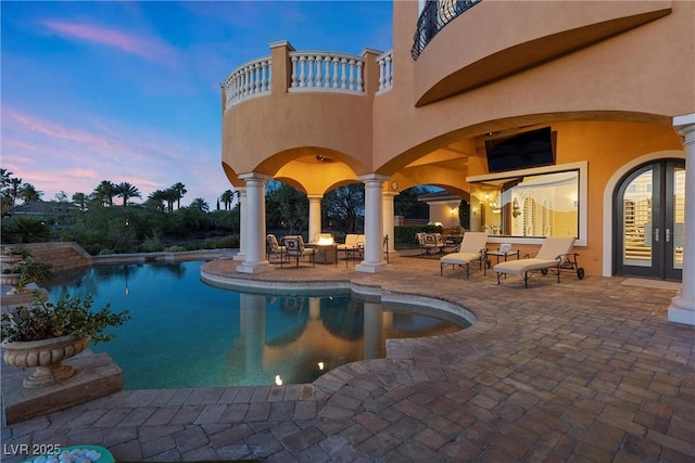 pool at dusk with a patio