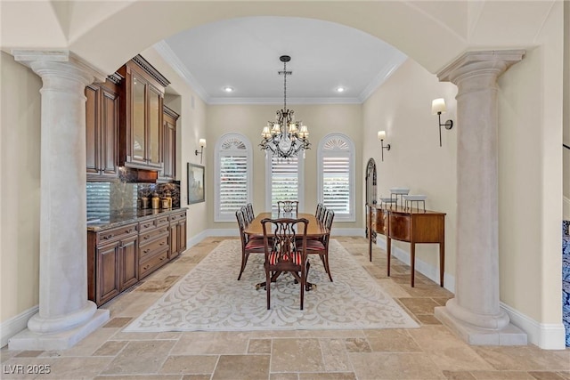 dining area featuring decorative columns, ornamental molding, and a chandelier