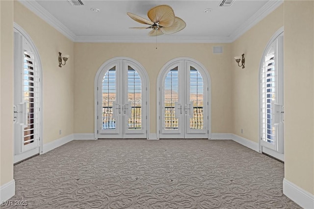 carpeted empty room featuring crown molding, ceiling fan, and french doors