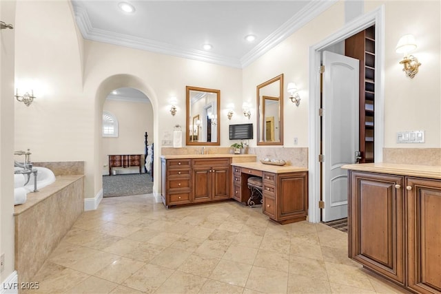 bathroom with crown molding, vanity, and tiled bath