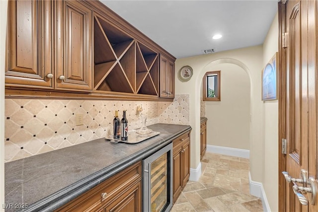 bar featuring wine cooler and backsplash