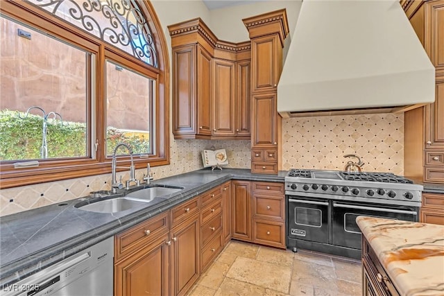 kitchen featuring premium range hood, sink, range with two ovens, dishwasher, and decorative backsplash