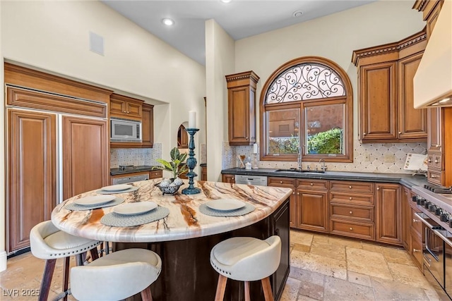 kitchen with sink, a center island, built in appliances, decorative backsplash, and custom exhaust hood