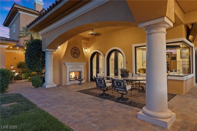 patio terrace at dusk with an outdoor fireplace