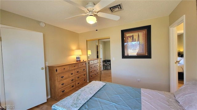 bedroom with ceiling fan, a closet, and a textured ceiling