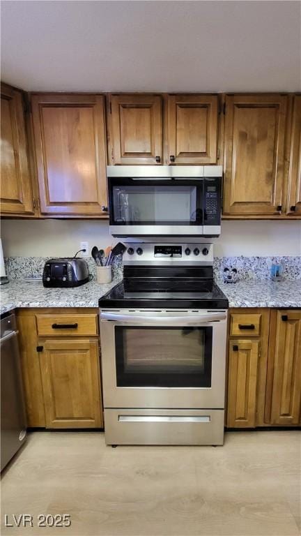 kitchen with stainless steel appliances and light stone countertops