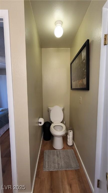 bathroom with hardwood / wood-style flooring and toilet