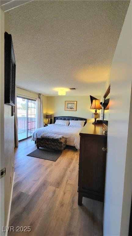 bedroom featuring hardwood / wood-style floors and a textured ceiling