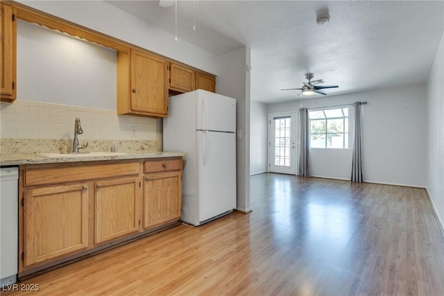 kitchen featuring ceiling fan, white appliances, sink, and light hardwood / wood-style flooring