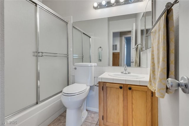 full bathroom featuring vanity, tile patterned floors, shower / bath combination with glass door, and toilet