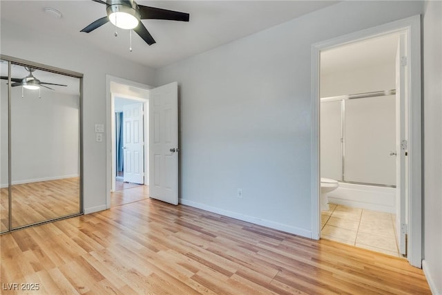 unfurnished bedroom with ensuite bath, light hardwood / wood-style flooring, a closet, and ceiling fan