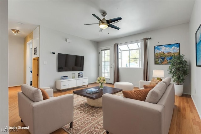 living room featuring ceiling fan and light hardwood / wood-style floors