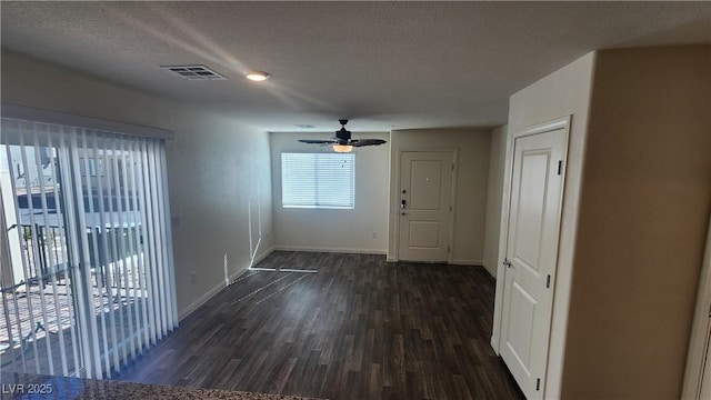 interior space with dark hardwood / wood-style flooring, ceiling fan, and a textured ceiling