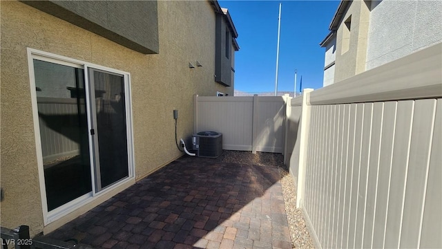 view of side of home with central AC and a patio