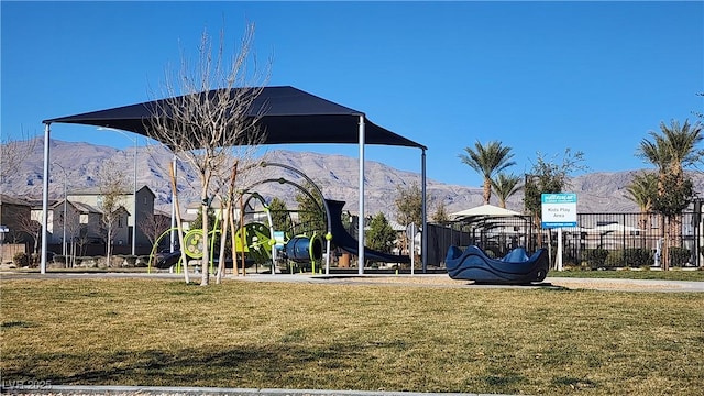 view of home's community with a mountain view, a yard, and a playground