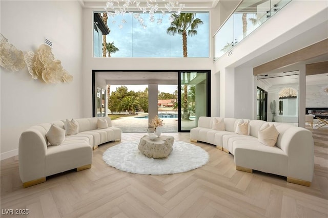 living room with a towering ceiling and light parquet flooring