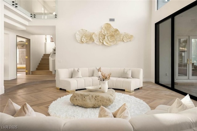 living room with a high ceiling and light parquet flooring