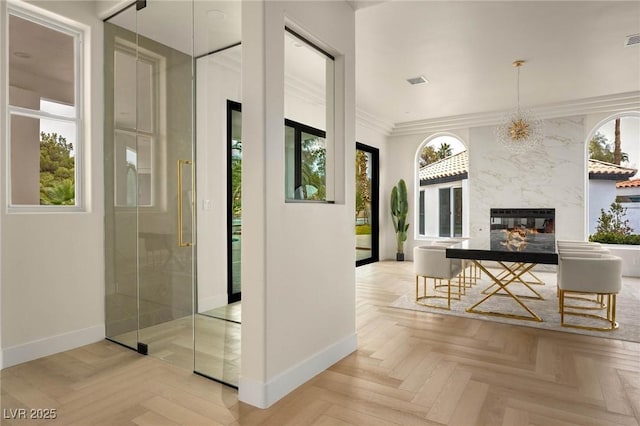 corridor featuring crown molding and light parquet flooring