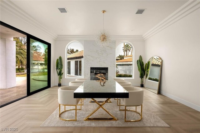 dining space featuring ornamental molding, light parquet flooring, a high end fireplace, and plenty of natural light