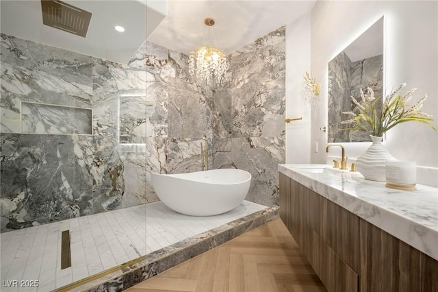 bathroom featuring vanity, parquet flooring, a bath, and an inviting chandelier