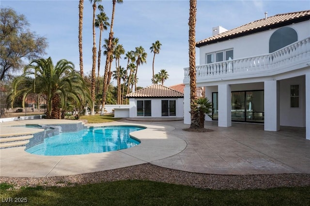 view of swimming pool featuring an outbuilding, a patio, and an in ground hot tub