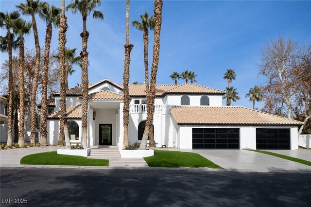 74 Innisbrook Ave, Las Vegas, NV 89113 - mediterranean / spanish house with a garage, a tile roof, driveway, and stucco siding