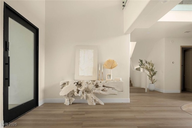 74 Innisbrook Ave, Las Vegas, NV 89113 - hall featuring wood finished floors, visible vents, baseboards, and stairway