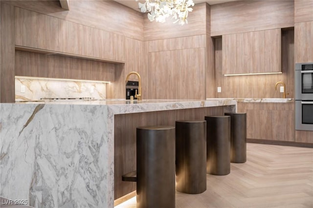 74 Innisbrook Ave, Las Vegas, NV 89113 - bar with stainless steel double oven and an inviting chandelier