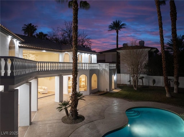 74 Innisbrook Ave, Las Vegas, NV 89113 - rear view of house featuring a balcony, fence, a patio, a fenced in pool, and stucco siding