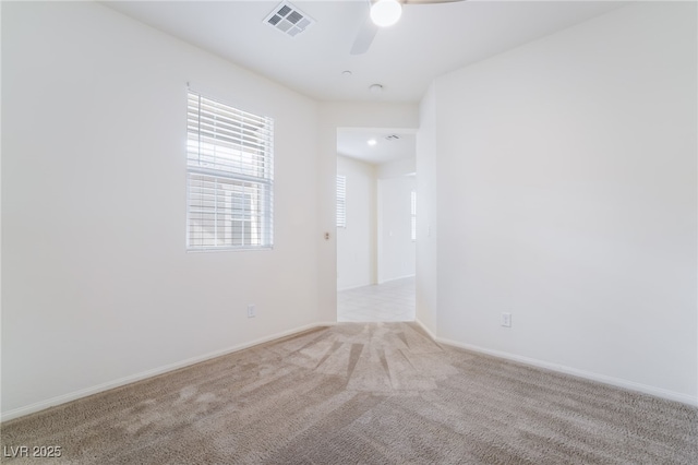 unfurnished room with light carpet, baseboards, visible vents, and a ceiling fan