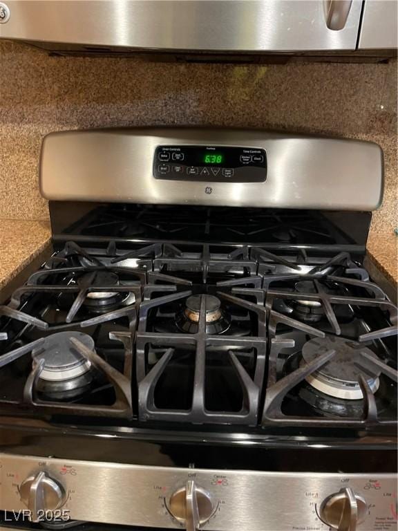 interior details featuring backsplash and gas stove