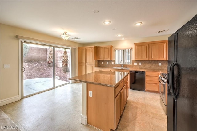 kitchen with light brown cabinets, a kitchen island, a sink, backsplash, and black appliances