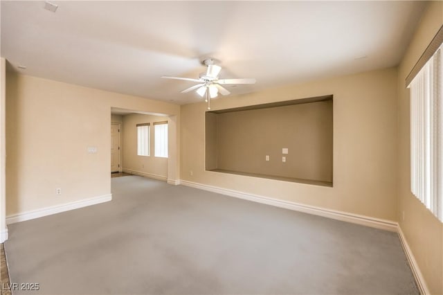 carpeted spare room with ceiling fan and baseboards