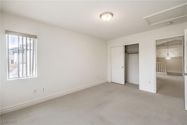 unfurnished bedroom featuring a closet, light carpet, and baseboards