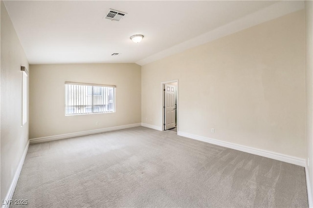 carpeted empty room featuring vaulted ceiling, visible vents, and baseboards