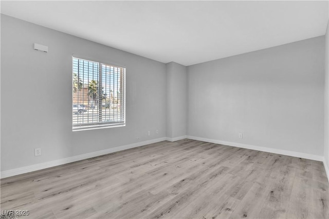 empty room featuring light wood-style flooring and baseboards