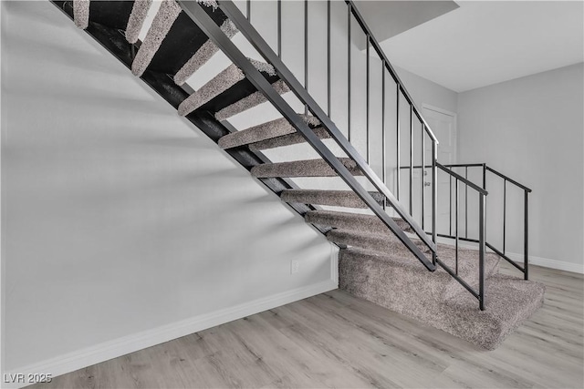 stairway featuring baseboards and wood finished floors