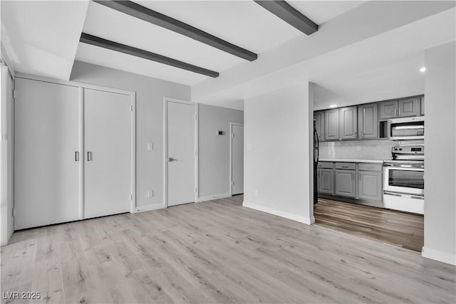 kitchen with light countertops, decorative backsplash, gray cabinetry, appliances with stainless steel finishes, and beamed ceiling