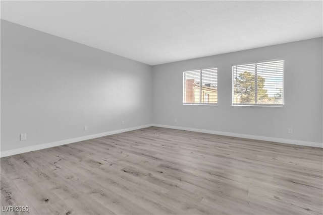 spare room with light wood-style floors and baseboards