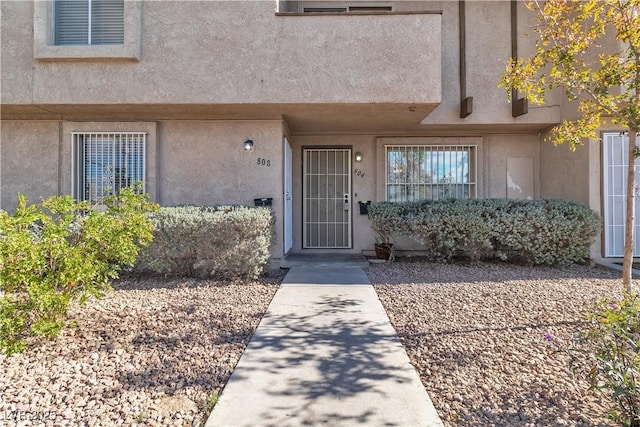 doorway to property featuring stucco siding