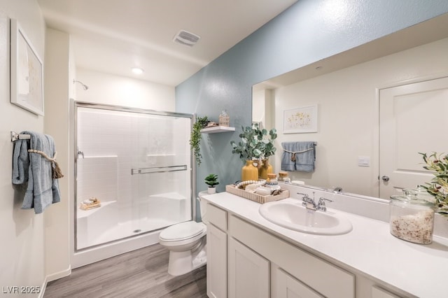 bathroom with walk in shower, vanity, toilet, and hardwood / wood-style floors