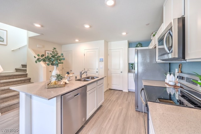 kitchen featuring sink, a center island with sink, white cabinets, and appliances with stainless steel finishes