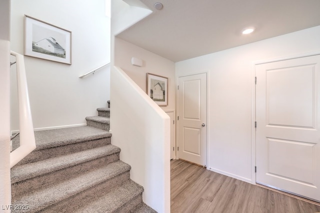 stairs featuring hardwood / wood-style floors