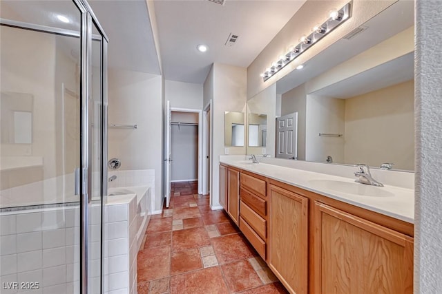 bathroom with double vanity, a garden tub, visible vents, and a sink