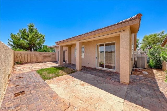 back of property with central AC, a patio area, a fenced backyard, and stucco siding