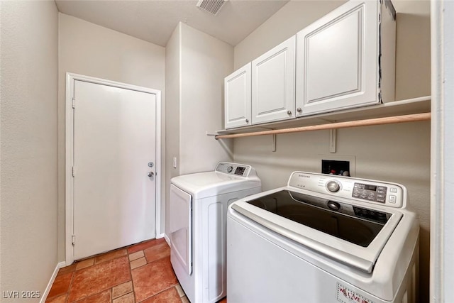 clothes washing area with cabinet space, stone finish flooring, visible vents, and washer and clothes dryer