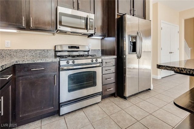 kitchen featuring appliances with stainless steel finishes, dark brown cabinets, and light tile patterned floors