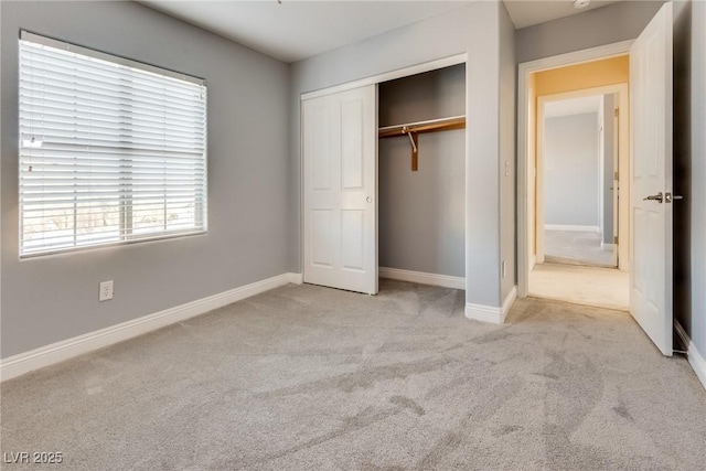 unfurnished bedroom featuring a closet and light carpet